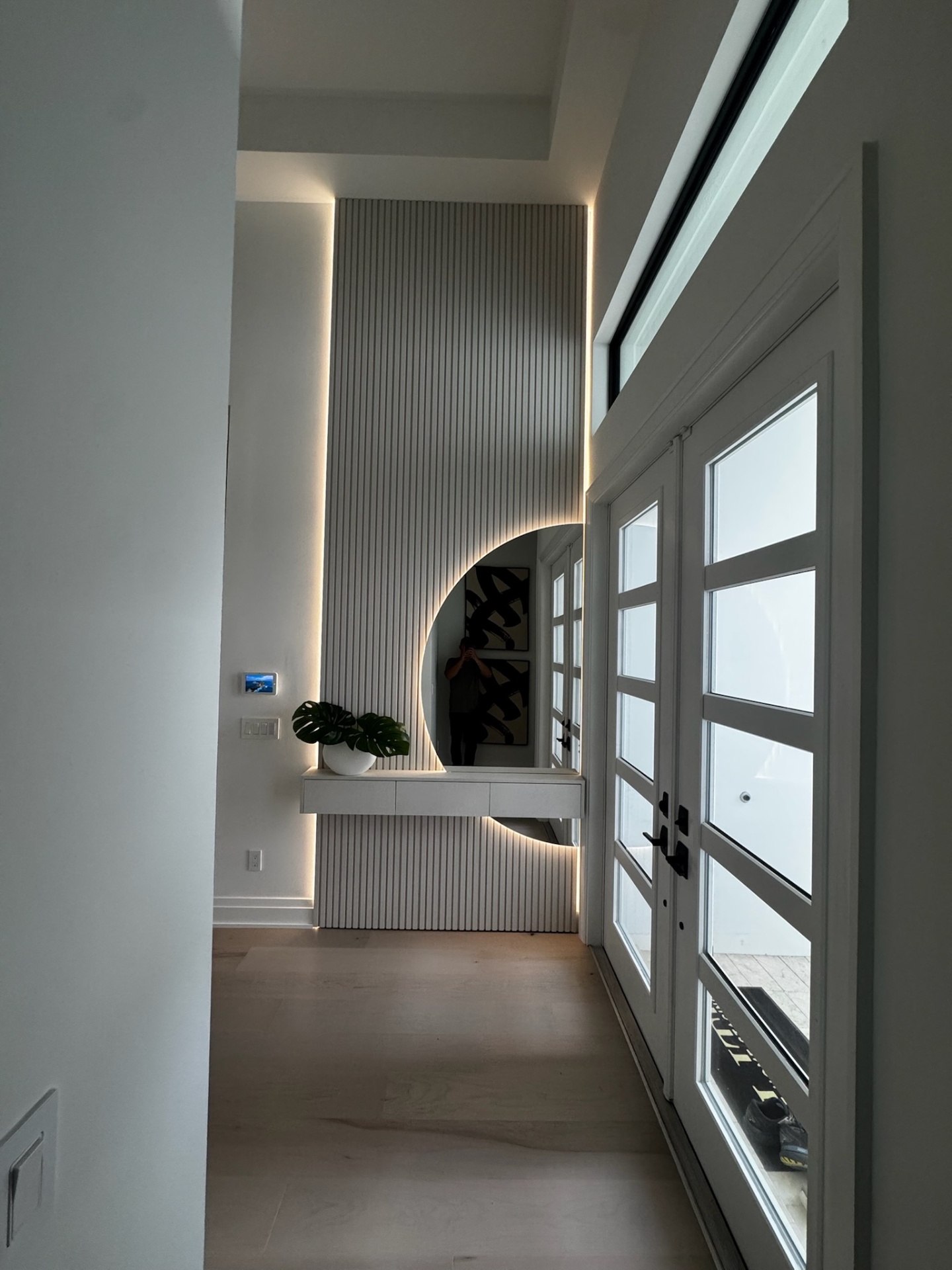 Custom slat wall foyer with floating console and arched cutout